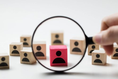 Searching for talent or looking for employee concept using magnifying glass and wooden cube with people icon